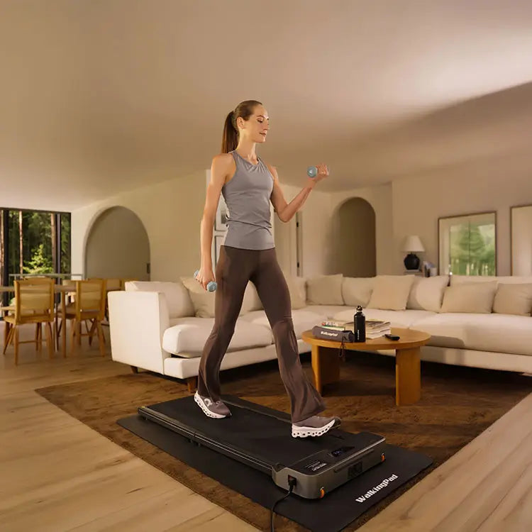 Woman walking on a treadmill in a bright home office